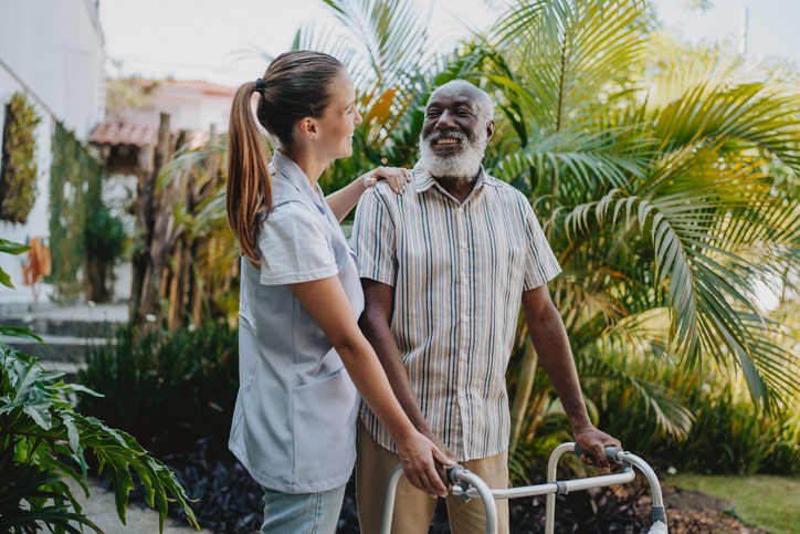 Caregiver assisting senior man on his daily walk