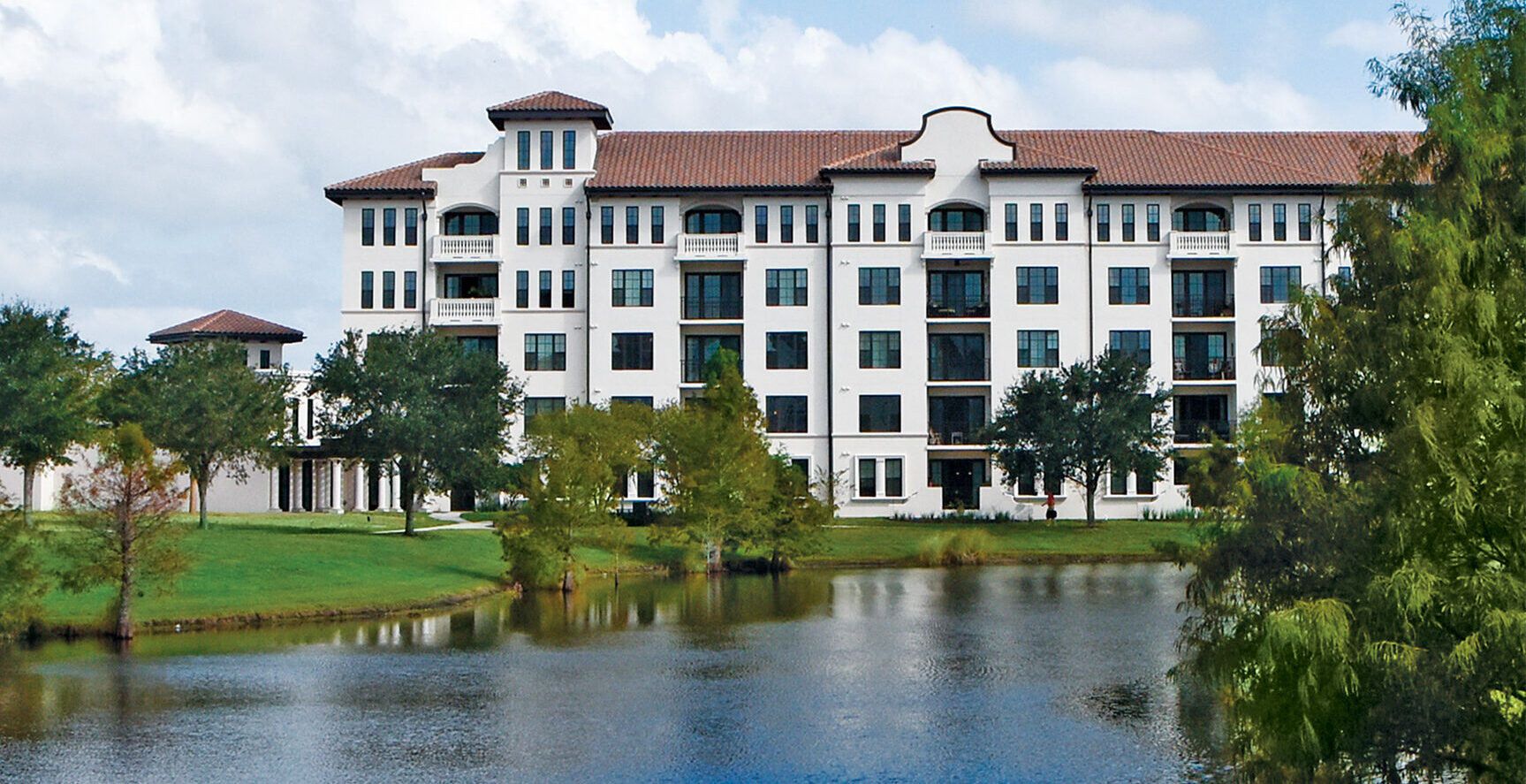 lakeside building with blue sky and beautiful greenery