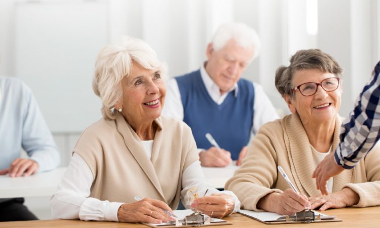 A group of seniors in a classroom setting looking at the front of the room
