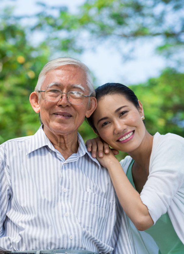 Portrait of happy senior man and his adult daughter leaning on his shoulder