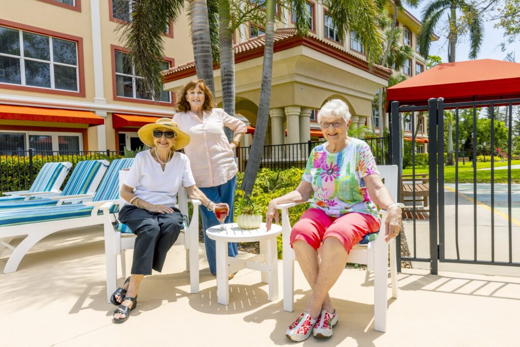Senior friends sharing a drink by the pool