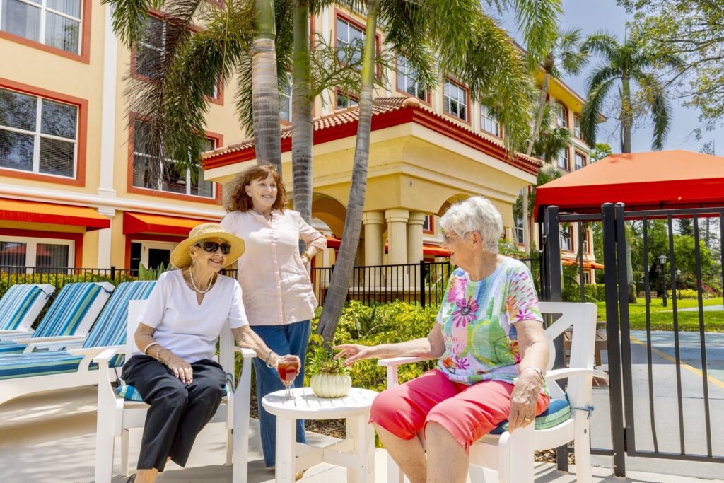 Senior friends sharing drink by the pool
