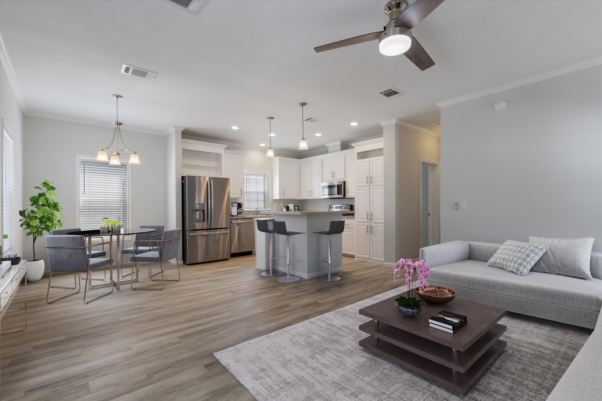 open, contemporary living room looking into the kitchen with an island and bar stools