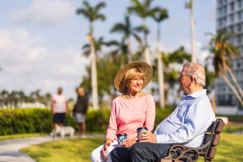 senior outside talking while sitting on bench