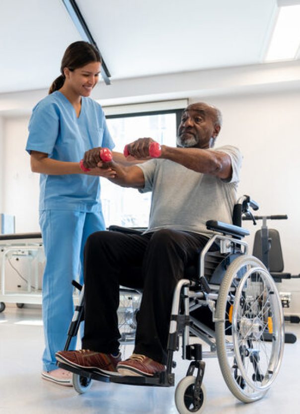 Cheerful therapist correcting the posture of her black senior patient on a wheelchair working out his arms with dumbbells Cheerful therapist correcting the posture of her black senior patient on a wheelchair working out his arms with dumbbells - healthcare concepts - Incidental patient and therapist at background