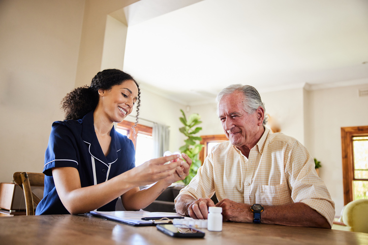 Senior giving man his medication