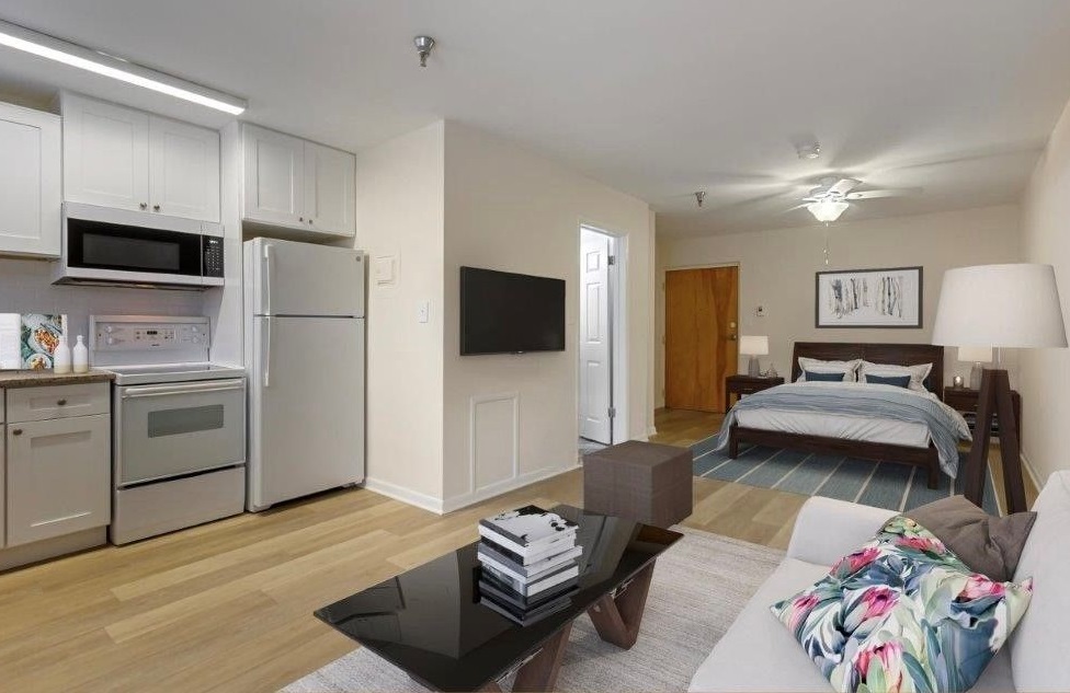 living room looking into contemporary, open kitchen with bed area in background