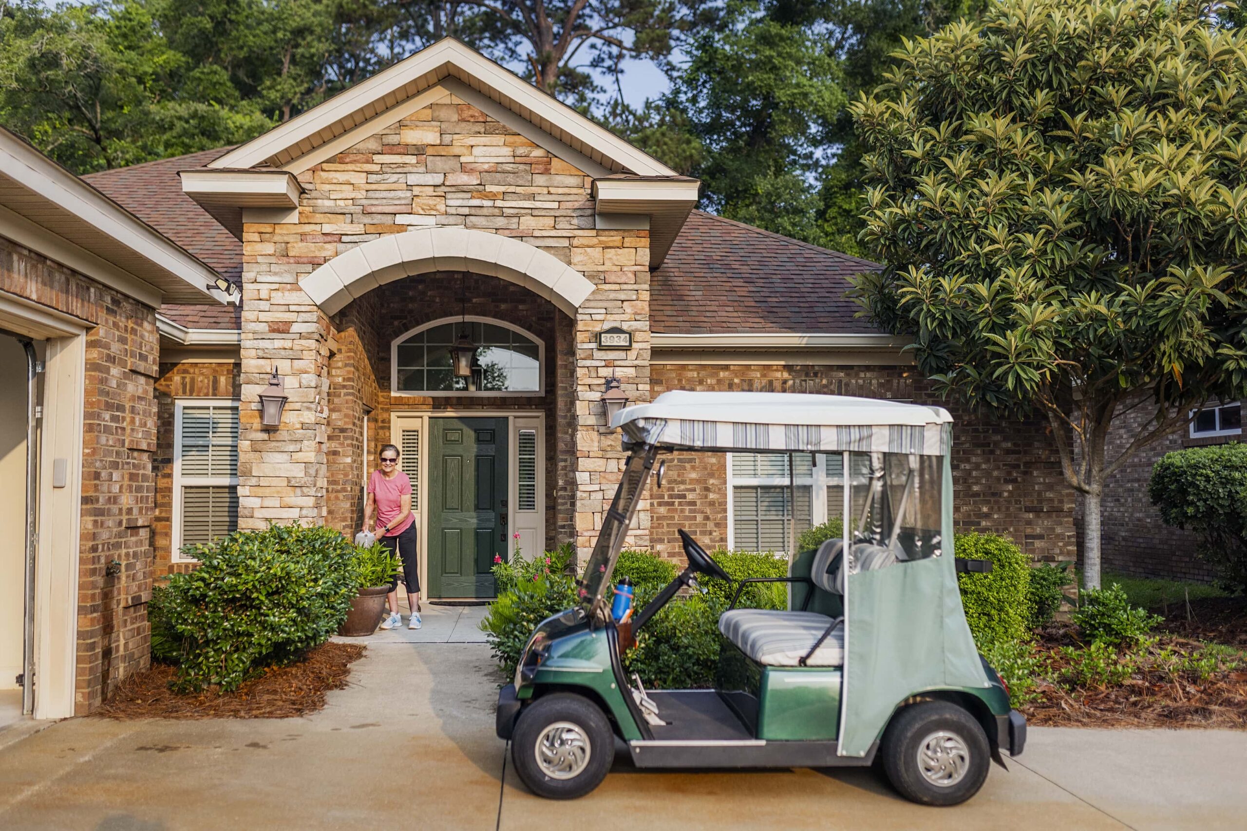 Exterior of Villa with Golf Cart and Senior Woman Smiling