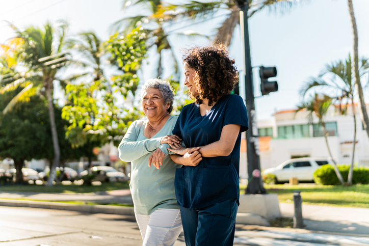 Caregiver assisting senior woman on a walk