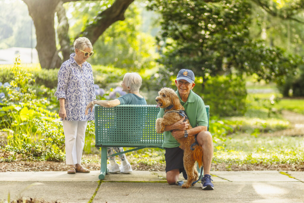 Seniors Smiling with Dog Outside