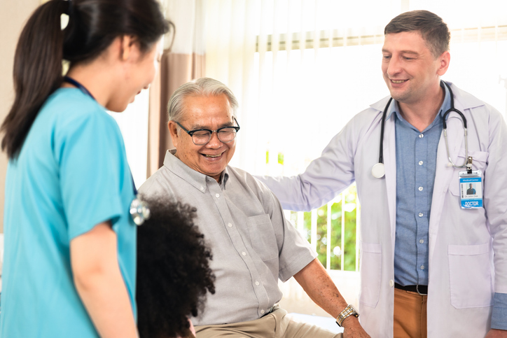 Doctor and nurse helping patient, smiling