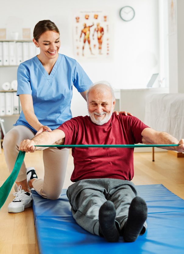 Doctor or nurse caregiver exercise with senior man at clinic or nursing home