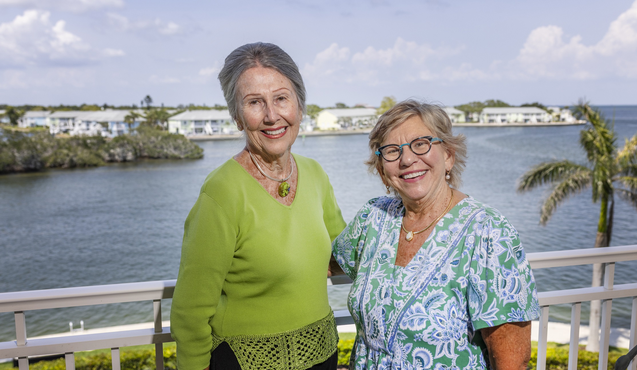 two woman stand on balcony overlooking Little Bayou in Pinellas Point smiling