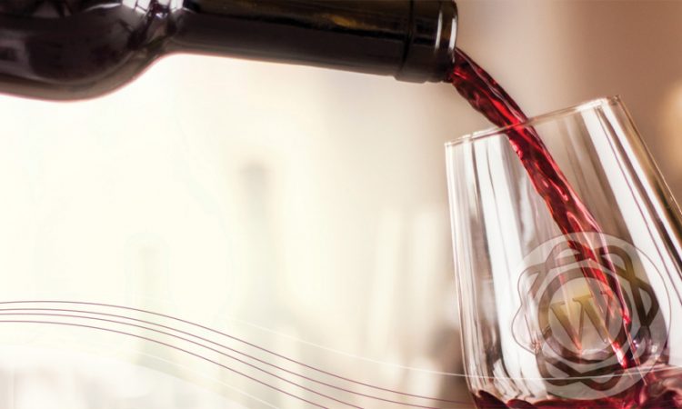 A bottle of red wine being poured into a glass
