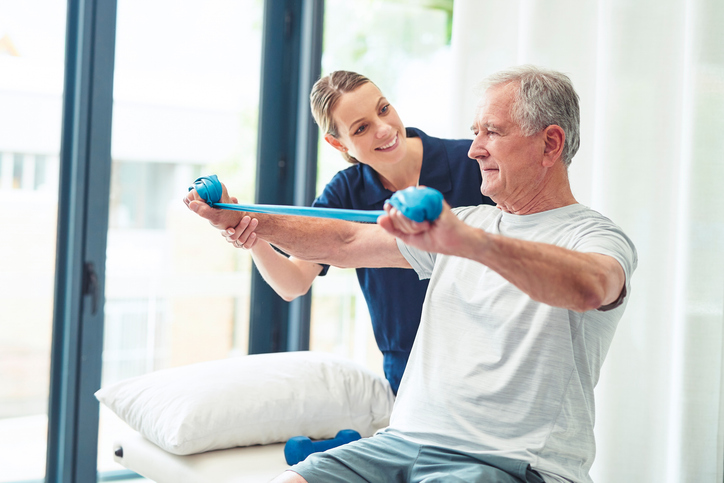 rehabilitation with a senior man and therapist training in a health clinic.