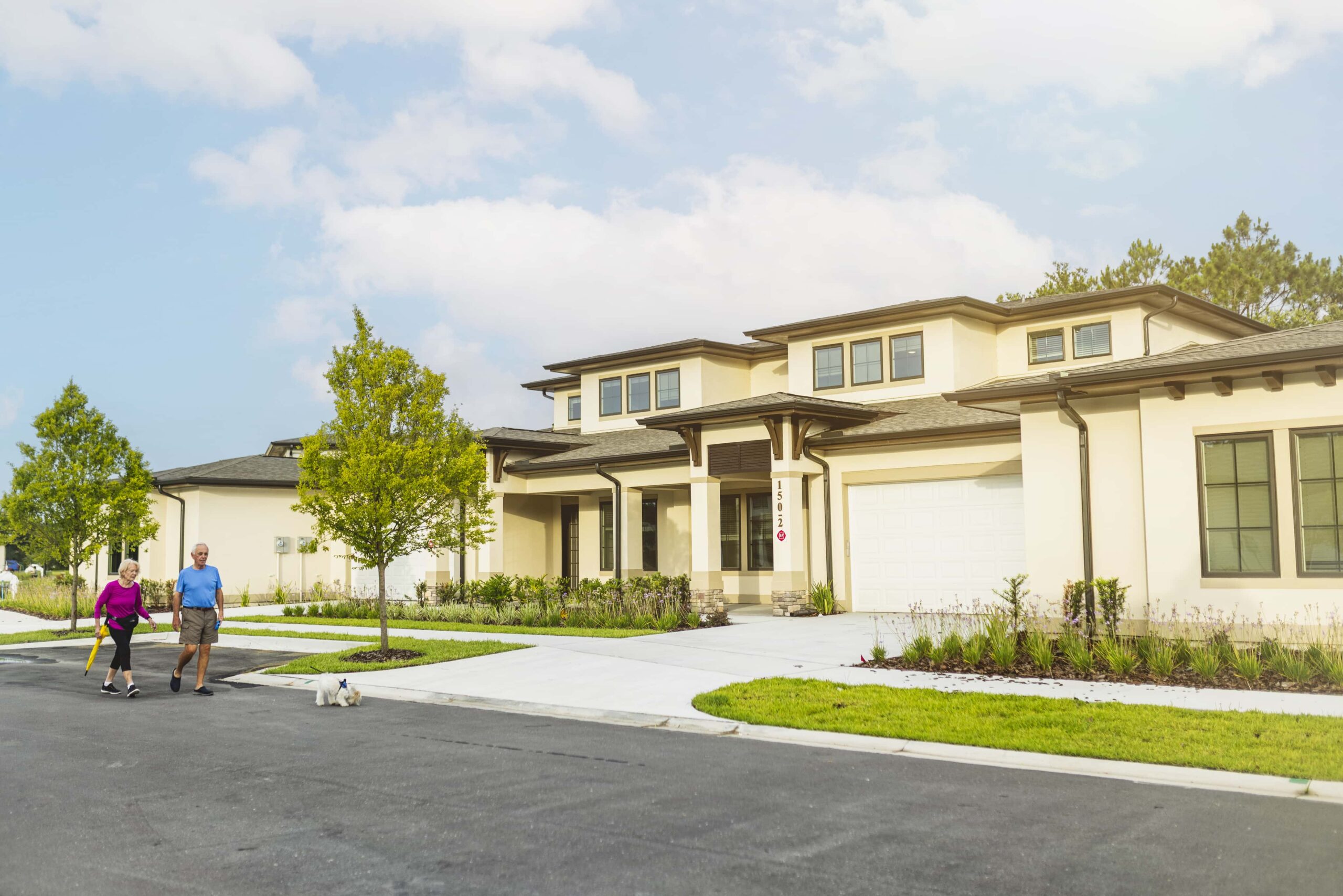 Street view of seniors walking their dog through the neighborhood