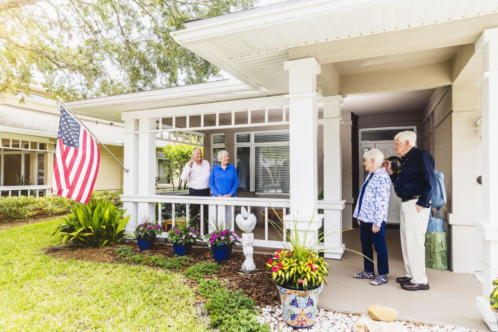 Senior friends visiting greeted on front porch