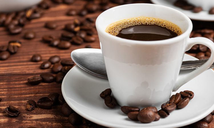 Cup of coffee on a wooden table with coffee beans