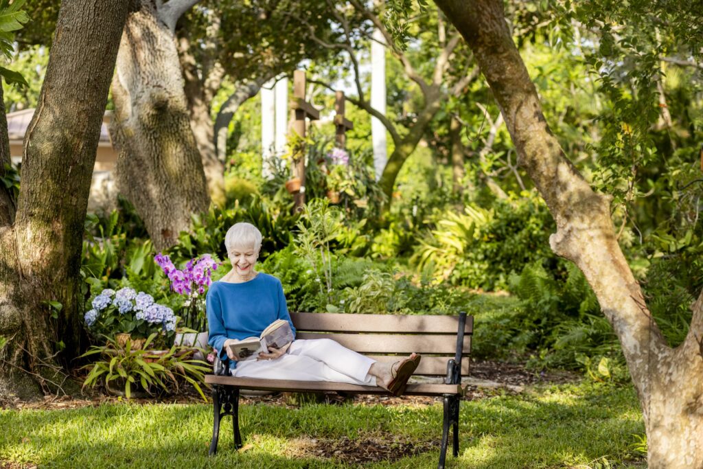 Senior reading on a summer night sitting on a bench