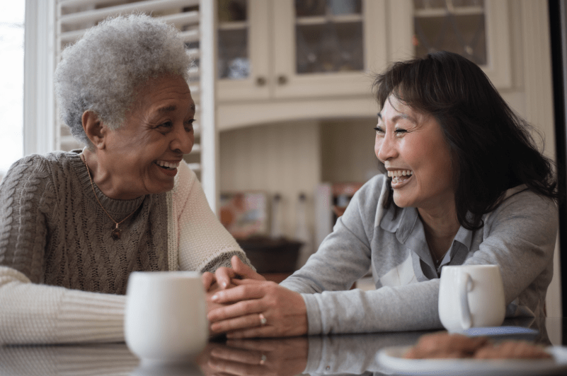 Senior with her friend visiting having a cup of coffee