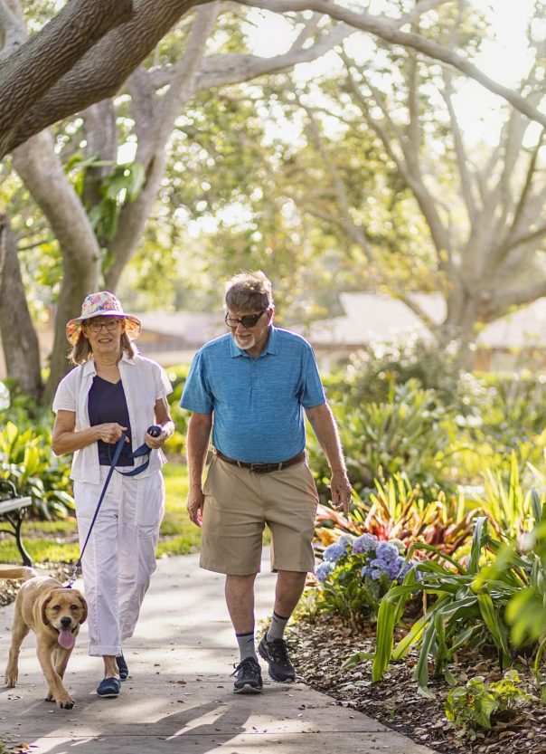 Senior couple taking dog on a walk