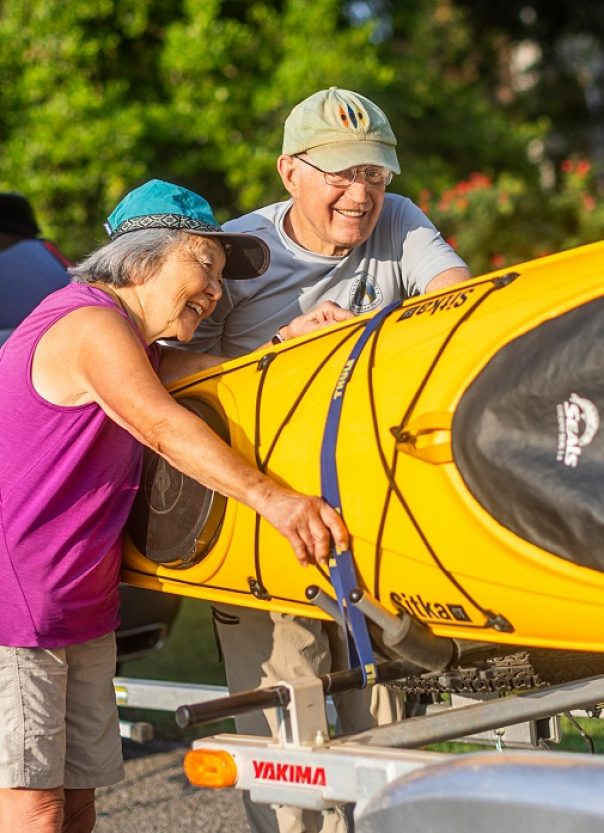 WSC kayak couple husband and wife strap yellow kayak to SUV