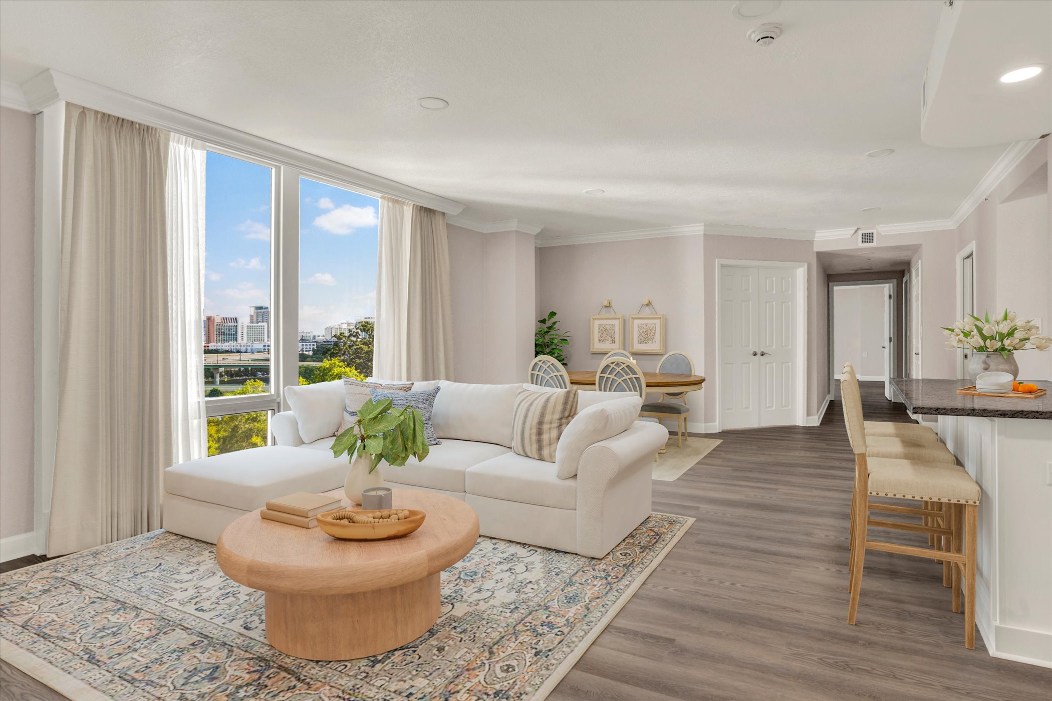 spacious living room with contemporary open kitchen and floor to ceiling windows overlooking downtown Orlando