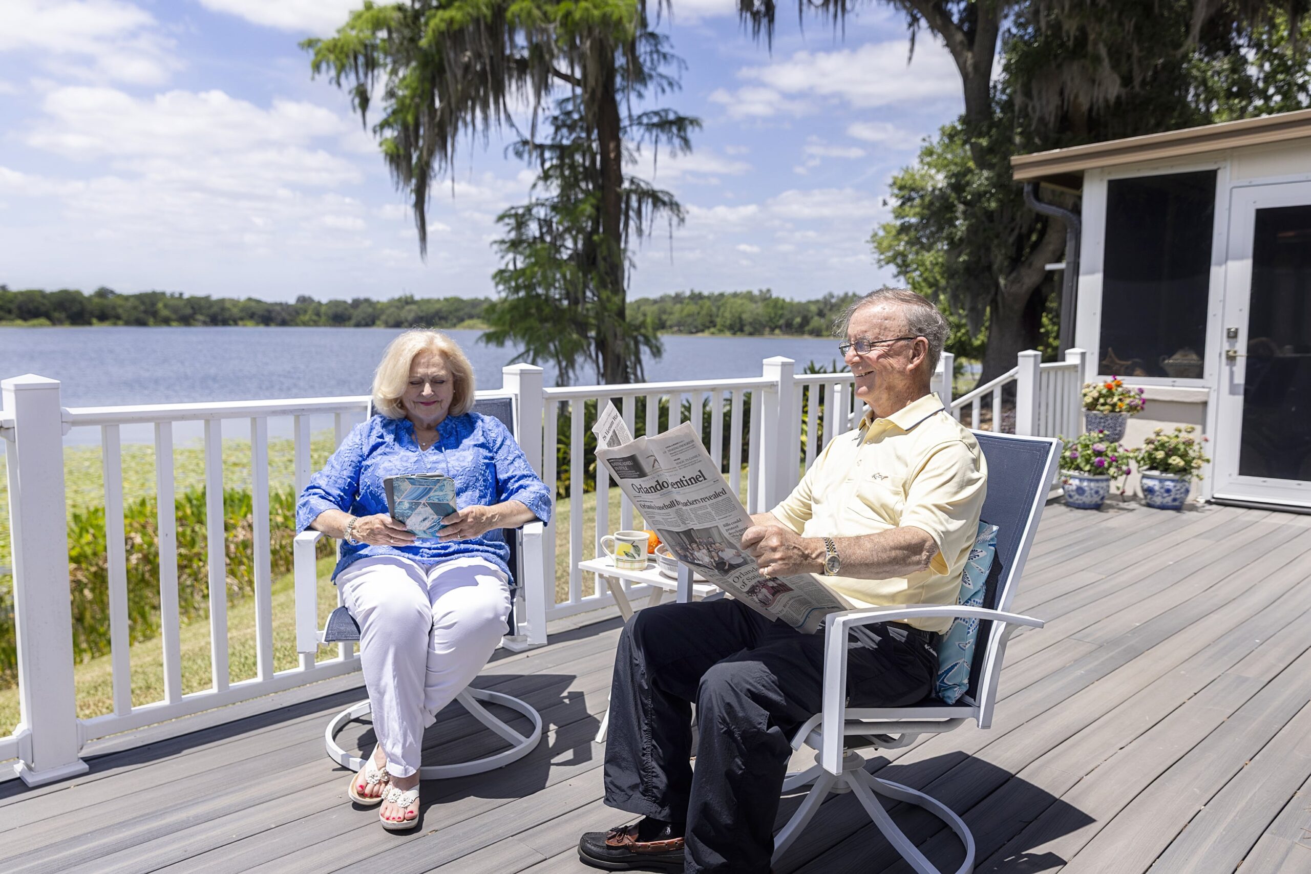 Senior couple reading newspaper on back porch