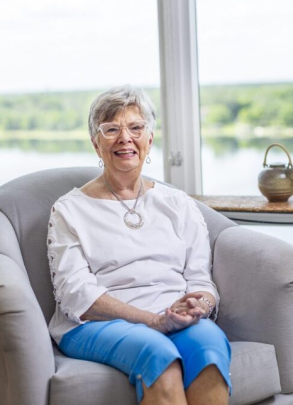 senior smiling, sitting in chair