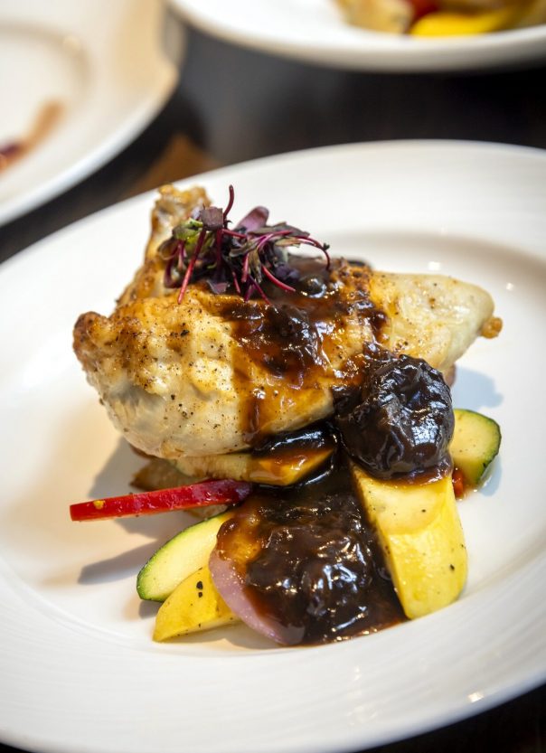 plump chicken breast with roasted prunes atop sauteed squash and fingerling potatoes