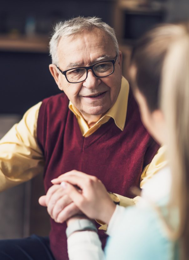 Home doctor is visiting senior man to check his health. Professional caregiver is assisting old man at his home.