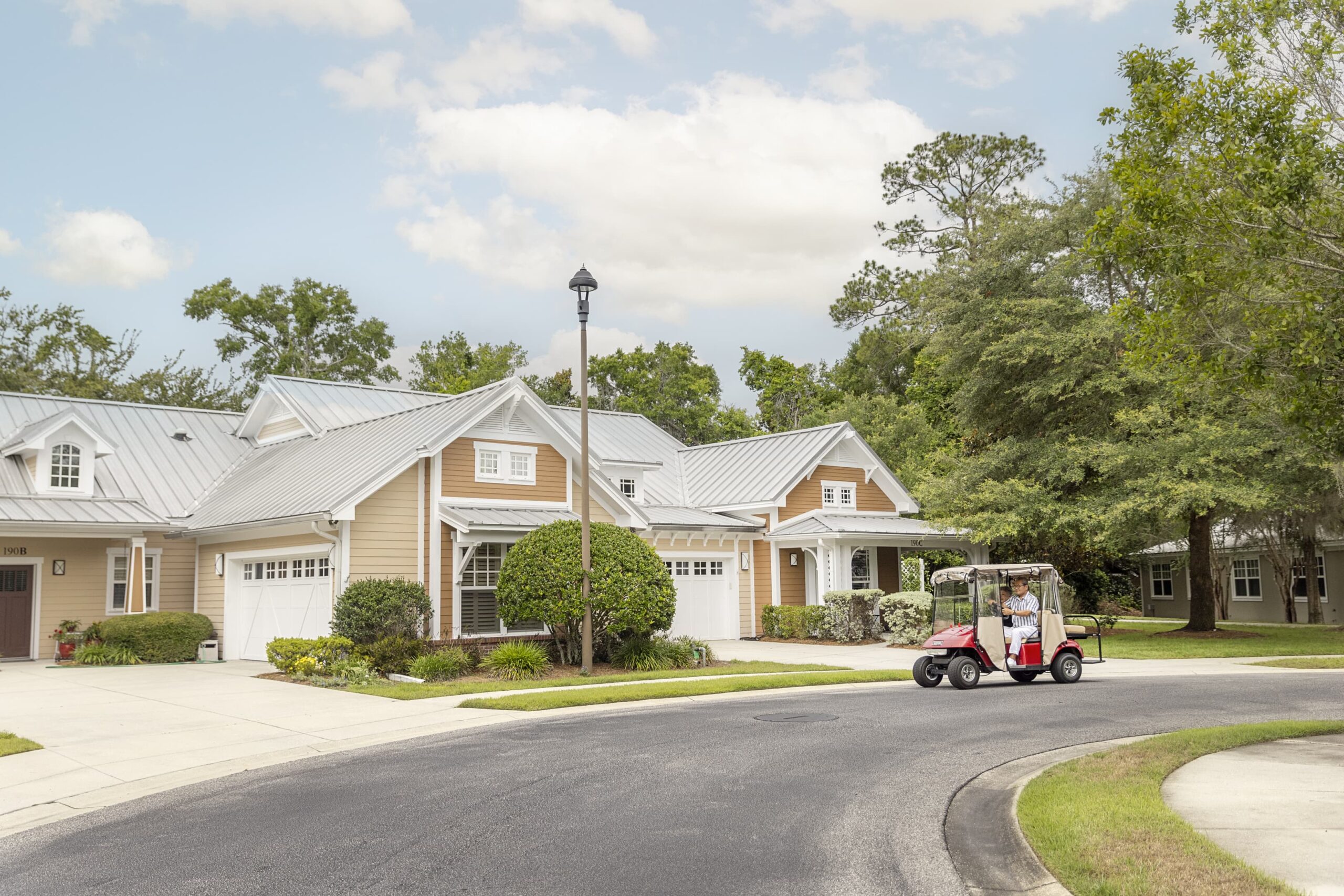 Residence home with man on golf cart at Westminster Woods at Julington Creek