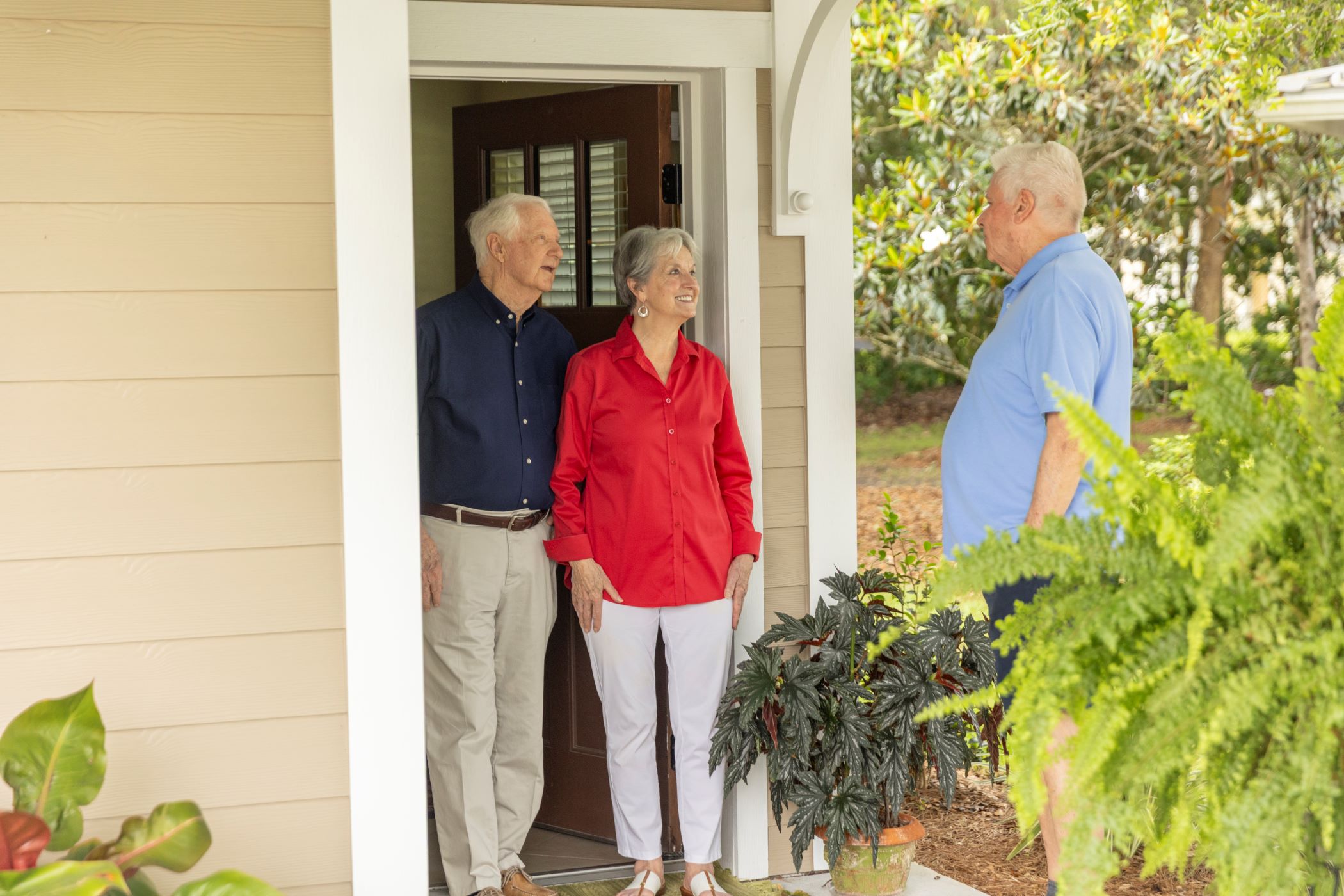 seniors standing outside of home talking to neighbor