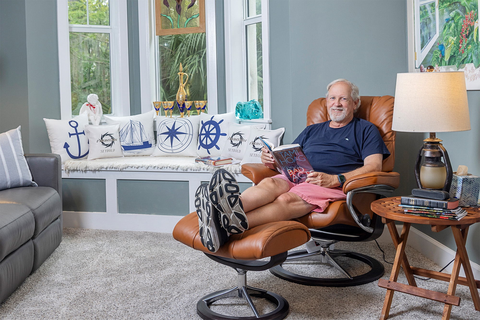 A senior man reading in an armchair in his living room