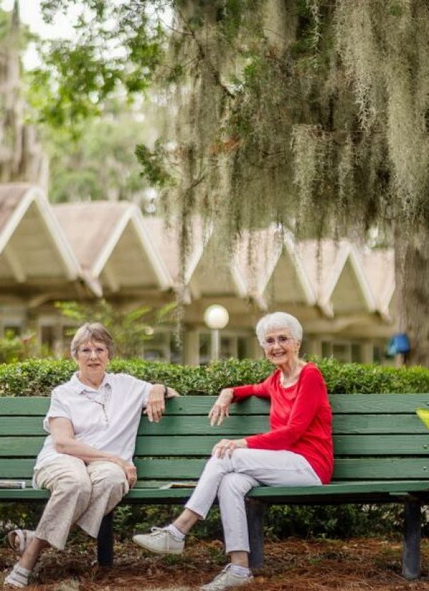Two senior woman talking on a bench outside