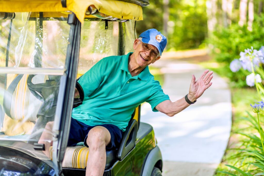 Senior man riding in golf cart
