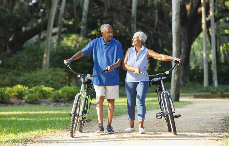 Senior Couple Walking Bikes