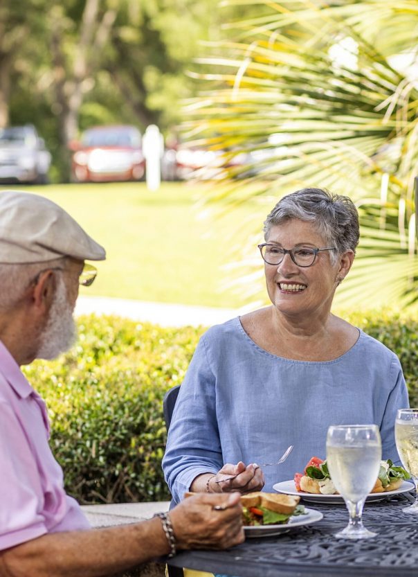 Senior couple smiling on patio table outside