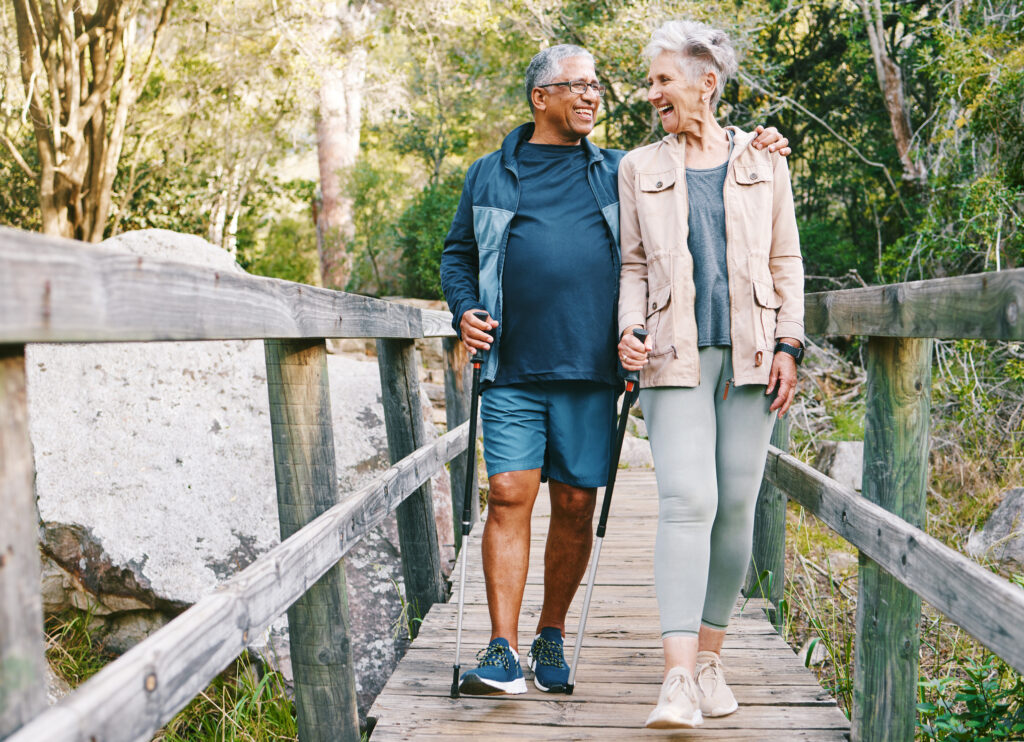 Senior couple walking in a park over a wooden bridge together