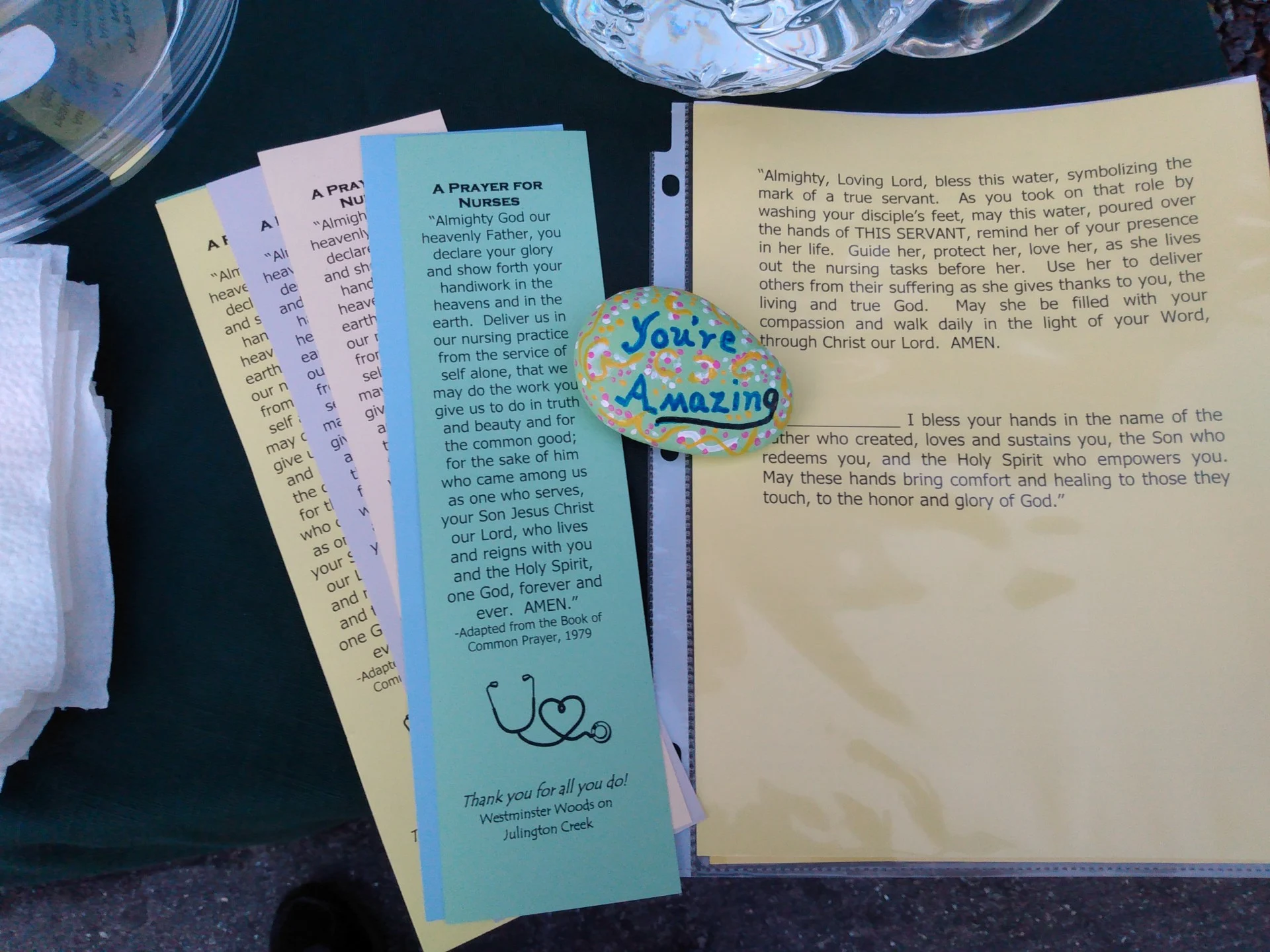 Chaplain's cart with printed prayers to hand out and a stone painted with the saying "You're Amazing".